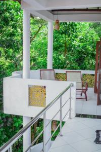 a porch with two chairs and a railing at SAKURAHANA VILLA AND AYURVEDA in Aluthgama