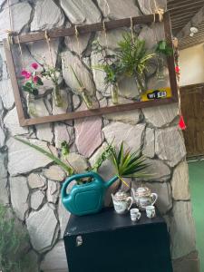 a table with a blue pot on it next to a stone wall at ACM Flat in Natal