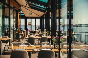 a restaurant with tables and chairs and windows at Slottsholmen Hotell och Restaurang in Västervik