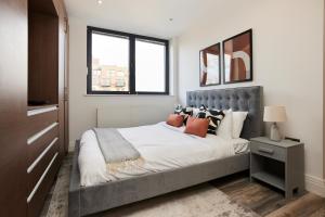 1 dormitorio con 1 cama grande y 2 ventanas en The Wembley Hideaway - Bright 2BDR Flat en Londres