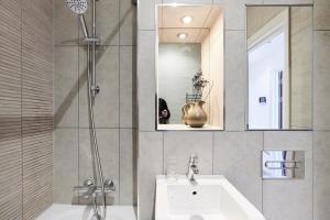 y baño con lavabo, ducha y espejo. en The Wembley Hideaway - Bright 2BDR Flat en Londres