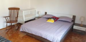 1 dormitorio con 1 cama con almohadas y silla en Prijeten prostoren apartma v hiši, en Pivka