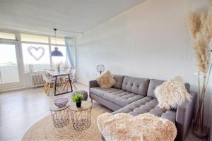 uma sala de estar com um sofá e uma mesa em Ferienpark - Haus L, App 0L0603 em Heiligenhafen