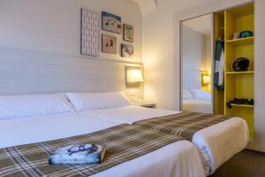 a bedroom with a bed with a pair of shoes on it at Hotel Cristina in Pas de la Casa