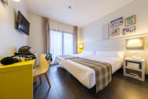 a hotel room with a large bed and a desk at Hotel Cristina in Pas de la Casa