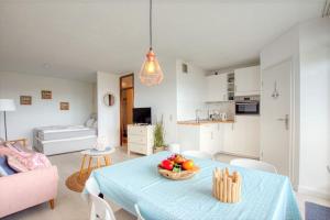 een woonkamer met een tafel met een fruitschaal erop bij Ferienpark - Haus L, App 0L0610 in Heiligenhafen