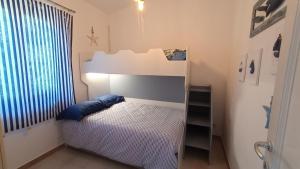 um quarto com uma cama branca e uma almofada azul em casa luisa em Cala Gonone