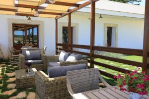 d'une terrasse avec des tables et des chaises en osier. dans l'établissement La Valle delle Rose, à Massafra