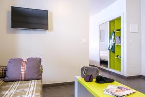 a living room with a couch and a tv on a wall at Hotel Cristina in Pas de la Casa