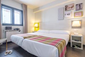 a hotel room with a large bed and a window at Hotel Cristina in Pas de la Casa