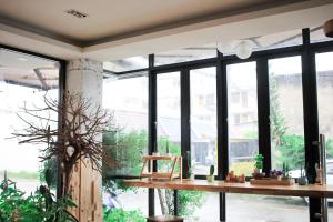 a room with large windows and a wooden table at Krabi P.N. Boutique House in Krabi