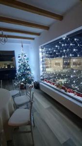 Un arbre de Noël dans une salle à manger éclairée dans l'établissement LukAmi Green Home, à Făgăraş