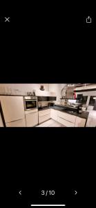 a kitchen with white appliances and a black picture at Elegantti studio lähellä Kuusamon keskustaa in Kuusamo