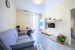 sala de estar con sofá, TV y mesa en La casa del Sole en Piacenza