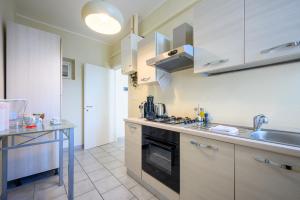 uma cozinha com um lavatório e um fogão forno superior em La casa del Sole em Piacenza