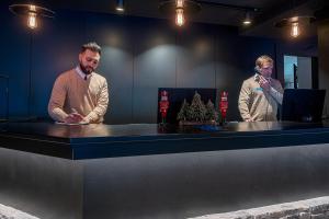 two men are standing at a counter in a bar at Hotel Cristina in Pas de la Casa