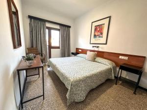 a hotel room with a bed and a window at Hostal Ca'n Pep in Sa Ràpita