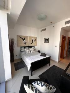 a bedroom with a bed and a couch at Amazing Double Room with En-suite, Marina and Sea views with shared kitchen in Dubai