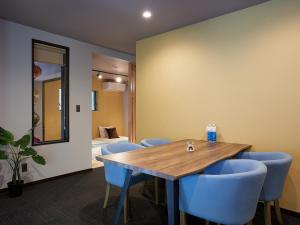 a conference room with a wooden table and blue chairs at Adan Resort 燈 - LANTERN - in Bise