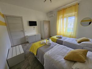 ein Hotelzimmer mit 2 Betten und einem TV in der Unterkunft sorrento sleepandgo in Sorrent