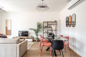 a living room with a table and red chairs at Akisol Portalegre Charm in Ponte de Sor