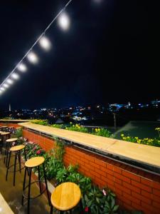 a rooftop bar with tables and chairs and lights at An Nhien Hotel in Da Lat