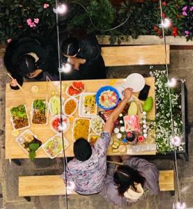 An Nhien Hotel في دالات: مجموعة من الناس يجلسون حول طاولة مع الطعام