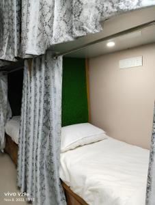 2 łóżka piętrowe w pokoju z zieloną ścianą w obiekcie Shree Madhvam AC Dormitory w mieście Waranasi