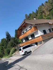 a white suv parked in front of a house at Bergzeit in Sankt Michael im Lungau