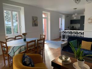 een woonkamer en een keuken met een tafel en stoelen bij Chic et cosy maison année 30 in Lorient