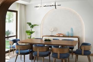 a dining room with a wooden table and blue chairs at Elara Villas in Dubai