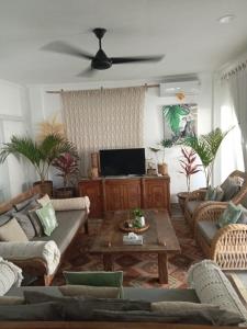 a living room with couches and a flat screen tv at Bali Court Hotel & Apartment in Legian