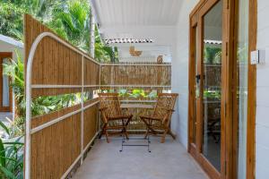 莫爾吉姆的住宿－Azora by Ayatana, Goa，门廊配有两把椅子和木栏杆
