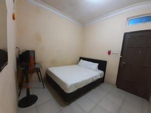 ein kleines Schlafzimmer mit einem Bett und einem TV in der Unterkunft SPOT ON 93428 Pinus Jaya Syariah in Palas 2