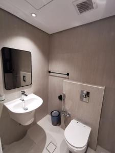 a bathroom with a white toilet and a sink at شقة فاخرة بالقرب من البوليفارد A13 in Riyadh
