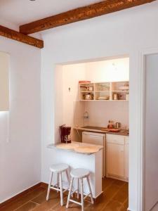 a kitchen with a counter and stools in a room at Malamo Home Studios, Lambi Beach in Lampi