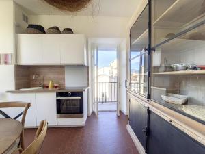 a kitchen with white cabinets and a table and a window at Nestor&Jeeves - REVE BLEU - View Port - BALCONY in Nice