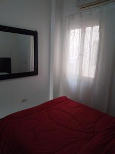 a bedroom with a red bed and a mirror at g. ground floor with garden in Hurghada