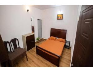 a small room with a bed and a desk at Bisman Lodge, Jabalpur in Jabalpur