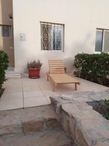 a wooden bench sitting in front of a building at g. ground floor with garden in Hurghada
