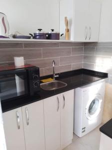 a kitchen with a sink and a microwave at g. ground floor with garden in Hurghada