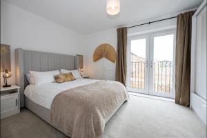 a bedroom with a bed and a large window at Luxury 2 Bed Holiday Home With Parking in Manchester
