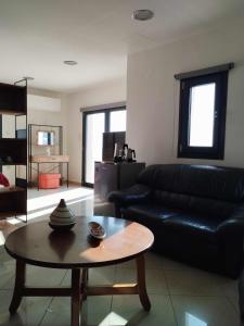sala de estar con sofá de cuero negro y mesa en Nest & nook en Chios