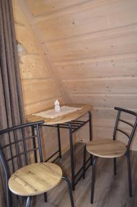 two tables and chairs in a room with a wooden wall at Willa Pod Lasem in Biały Dunajec