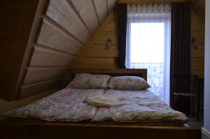 a bedroom with a bed with a wooden ceiling at Willa Pod Lasem in Biały Dunajec