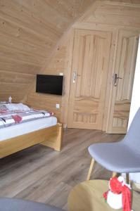een slaapkamer met een bed en een stoel in een kamer bij Willa Pod Lasem in Biały Dunajec