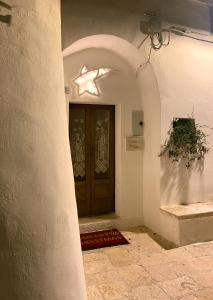 une arche menant à une porte avec une étoile sur elle dans l'établissement Trullo Zia Nina, à Alberobello