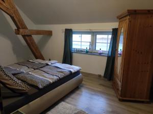 a small bedroom with a bed and a window at Ferienwohnung zum Getreidelager in Schwarzenbach an der Saale