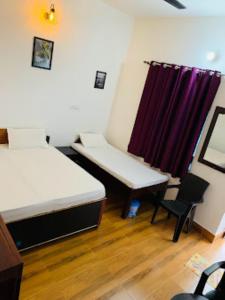 um quarto com duas camas e uma cortina roxa em Green Mountain Homestay Munshyari em Munsyari