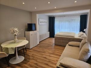 Zimmer mit 2 Betten, einem Tisch und einem Sofa in der Unterkunft Gästehaus Mäder in Bad Dürrheim